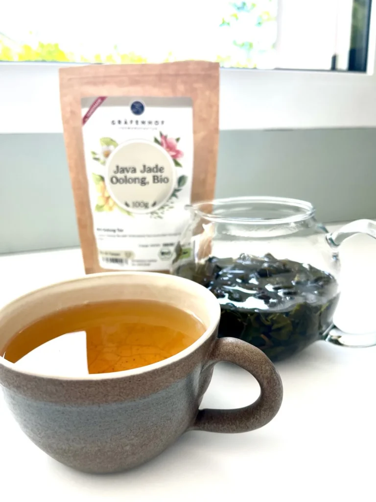 Bild einer Tasse und eines Glaskruges mit frischem Bio Oolong Tee – Sinnbild für Gesundheit, Gesundherhaltung, Salutogenese