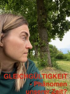 Nachdenklicher Blick einer Frau, mit Blick in die Landschaft, sich fragend, inwiefern Gleichgültigkeit ein Phänomen unserer Zeit ist.